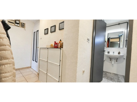 Flur mit Schrank und Blick ins Bad