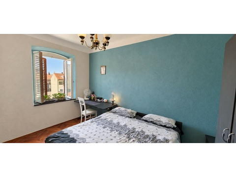 Schlafzimmer mit Doppelbett und Fensterläden