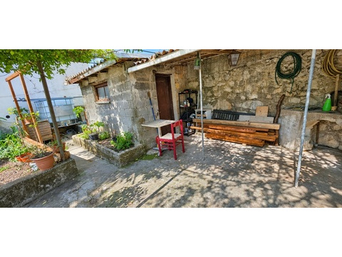 Steinhaus im Garten mit Tisch und Stühlen
