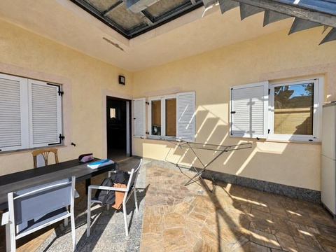 Überdachte Terrasse mit Tisch und Stühlen