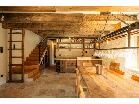 Wohnraum mit Treppe, Regalen und Holzbalkendecke