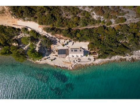 Bucht mit Steinhaus, Pinien und türkisfarbenem Wasser von oben