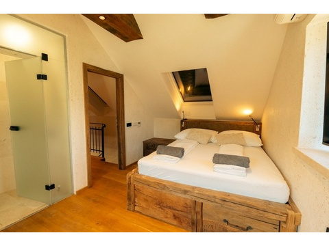 Schlafzimmer mit Doppelbett und Holzbalken