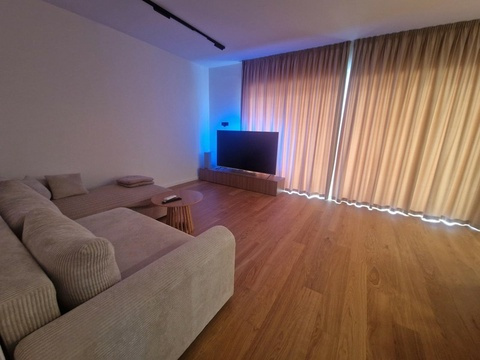 Wohnzimmer mit Fernseher und Sofa
