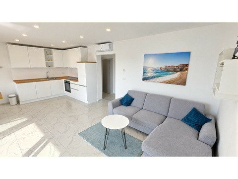 Wohnzimmer mit Sofa und offener Küche