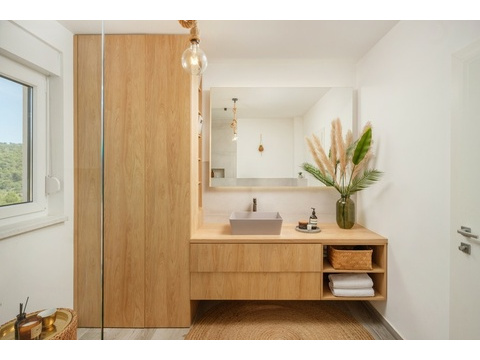 Badezimmer mit Waschtisch aus Holz und Spiegel
