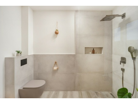 Dusche und Toilette mit großen Fliesen