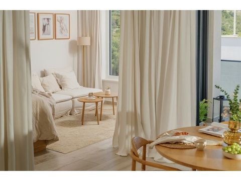 Wohnbereich mit Sofa, Vorhängen und Couchtisch