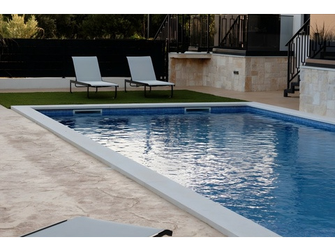 Swimmingpool mit Rasen und Sonnenliegen